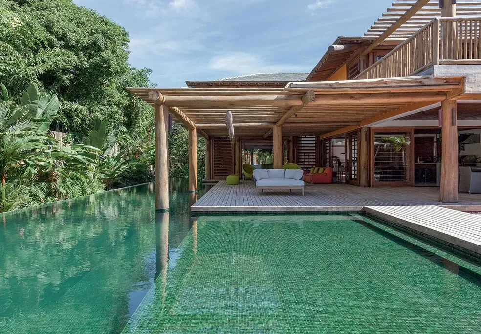 pergolado de madeira na beira da piscina